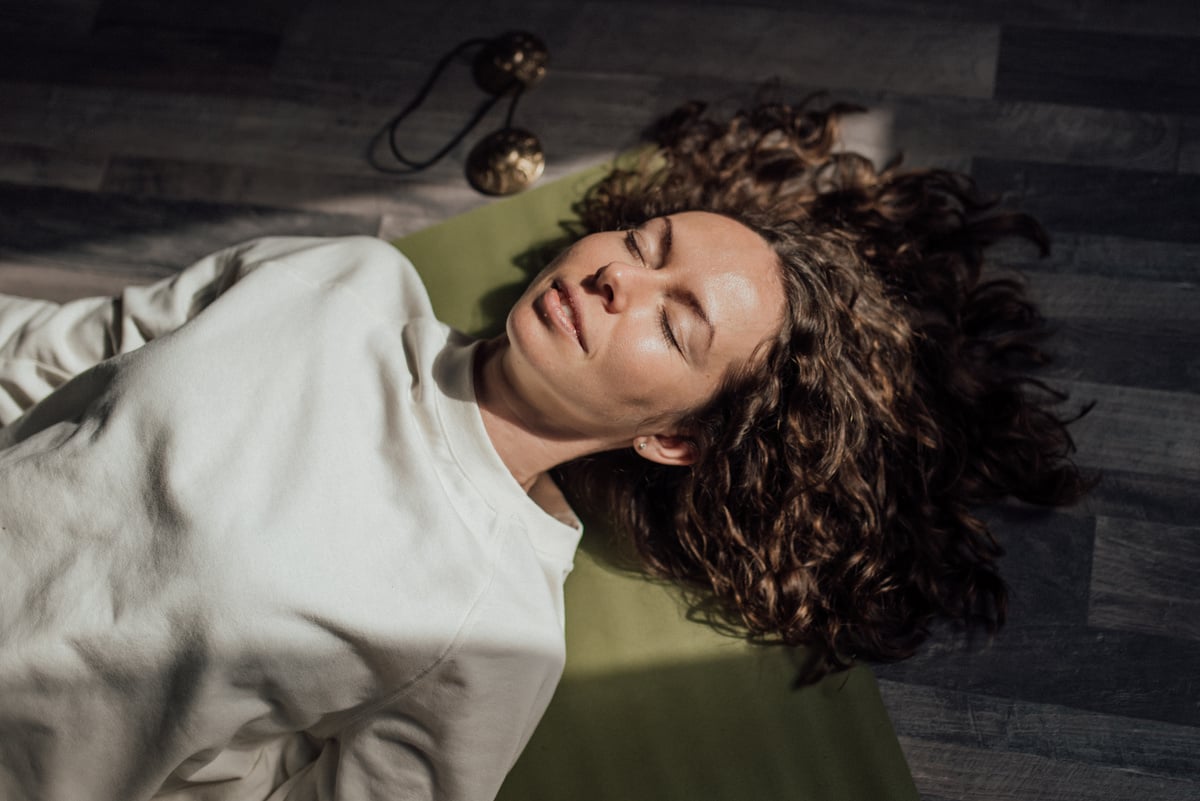 A Woman Lying on Yoga Mat With Eyes Closed